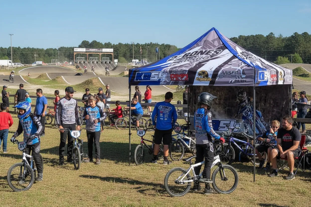 Custom 10x10 pop-up canopy tent at a BMX racing event with team and families