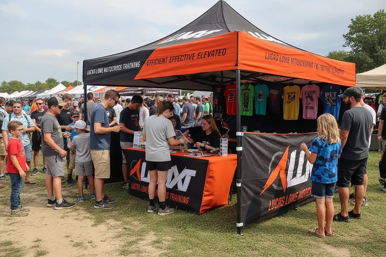 Custom 10x10 pop-up canopy tent with merchandise display at a motocross event