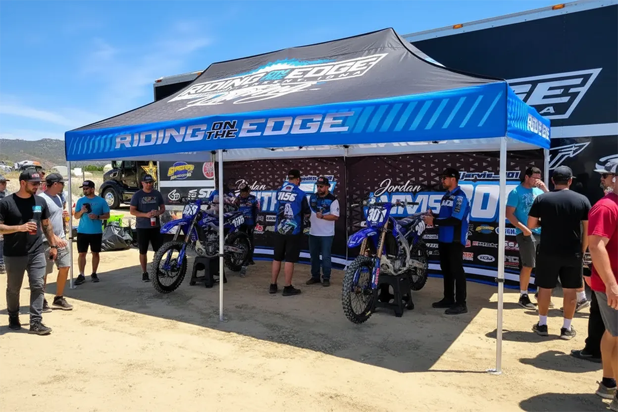 Custom 10x15 pop-up canopy tent with race team graphics at a national motocross event