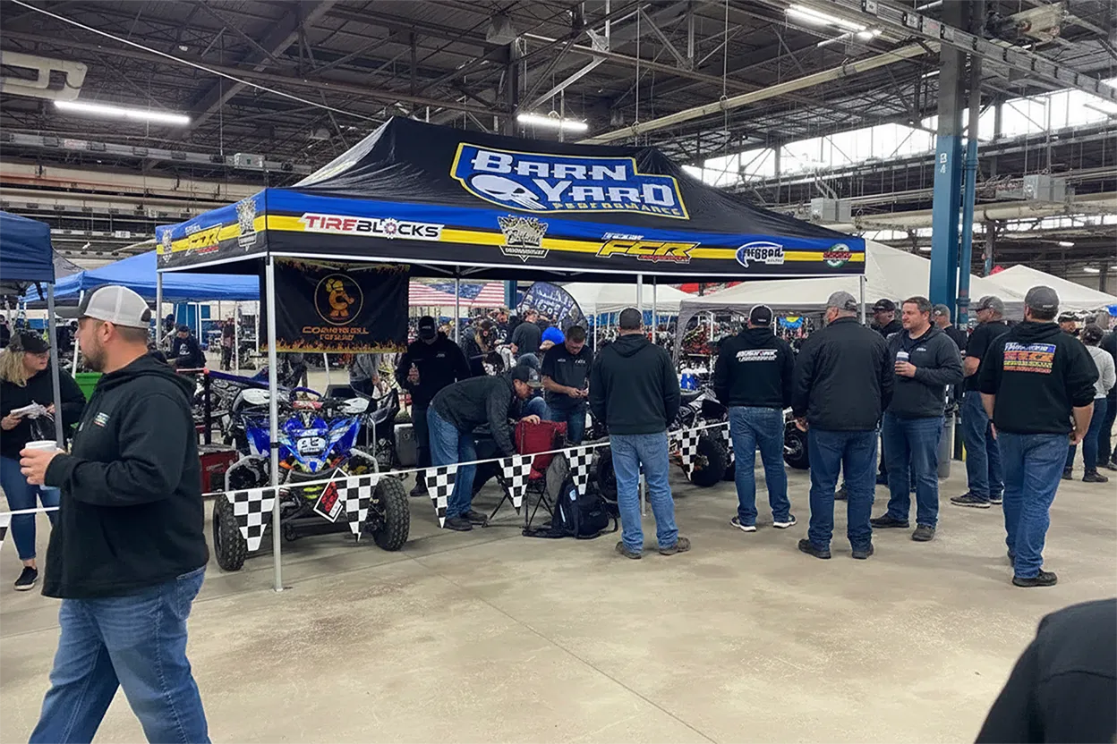 Custom 10x20 pop-up canopy tent set up at an indoor swap meet with branded graphics