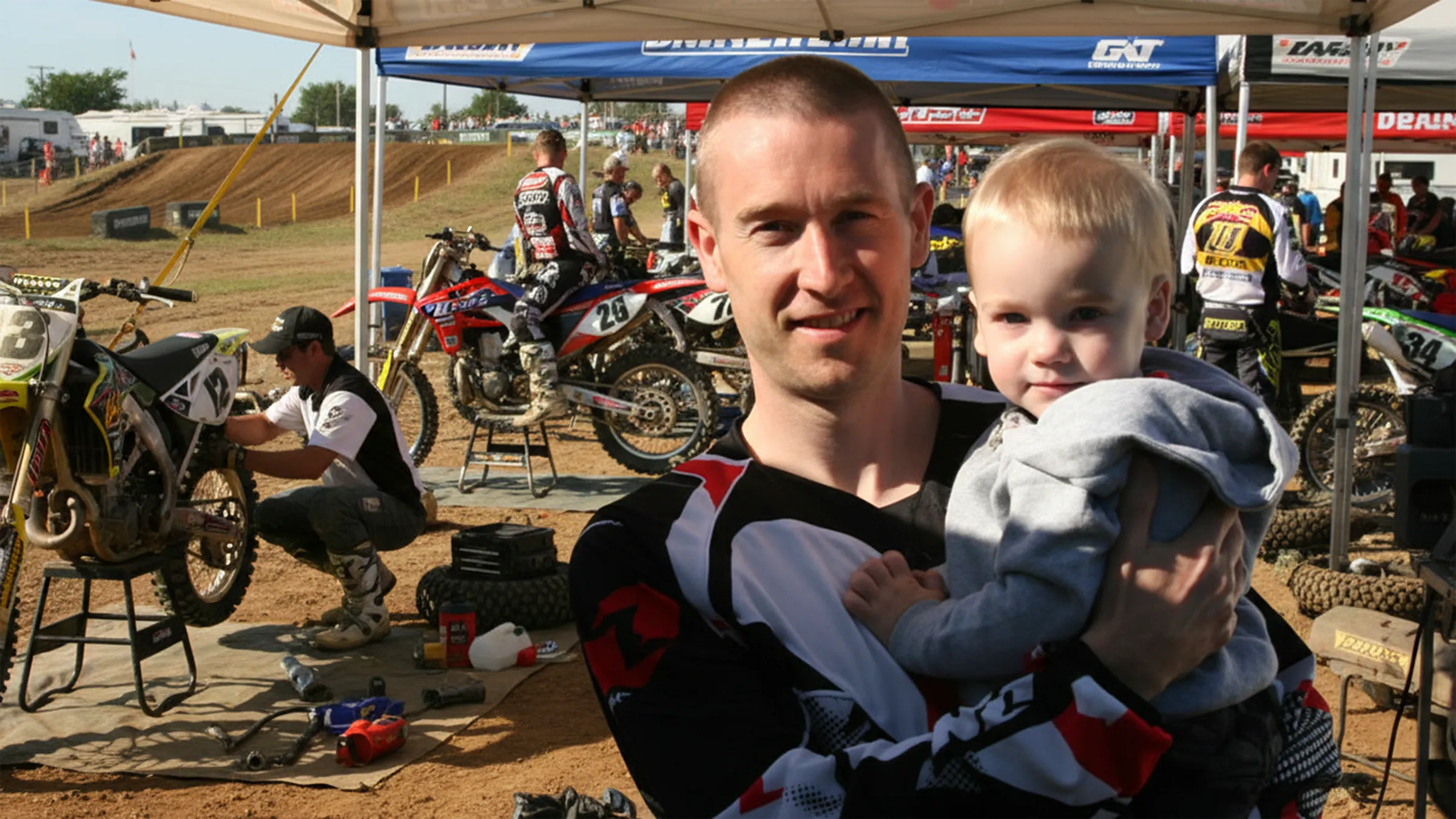 Founder of MyRaceNumber with his son at a motocross track, representing the family legacy behind the brand
